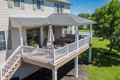 a house with a deck and an umbrella in the yard