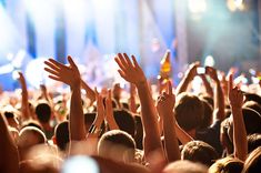 a crowd of people raising their hands in the air