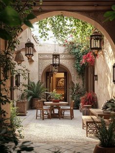 an outdoor dining area with potted plants and hanging lanterns on the wall, surrounded by greenery