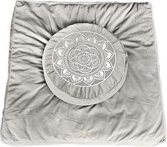 a round pillow with a flower design on the front and back cover in grey velvet