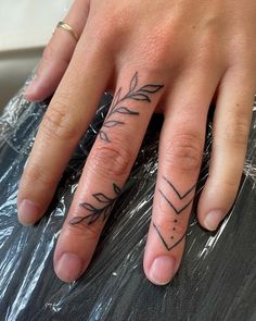 a woman's hand with an arrow tattoo on it