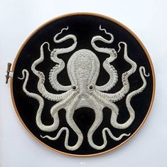 an embroidered octopus on a black and white plate