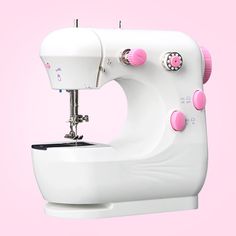 a white sewing machine with pink buttons on it