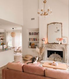 a living room with a cat sitting on the couch in front of a fire place