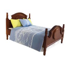 a wooden bed with blue and white bedspread on it's headboard