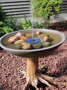 a bird bath with rocks and water coming out of it