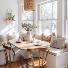 a table with two cups on it in front of a window filled with windowsills