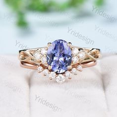 a tan and white ring with an oval blue sapphire surrounded by small diamonds on top