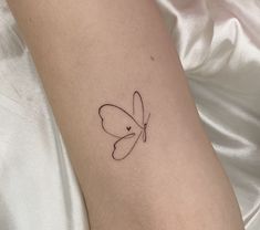 a small butterfly tattoo on the left inner arm and wrist, it looks like an outline