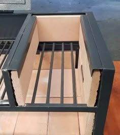 an open oven door sitting on top of a wooden table next to a brick floor