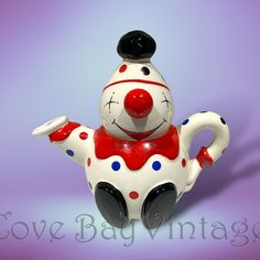 a ceramic clown figurine sitting on top of a purple background