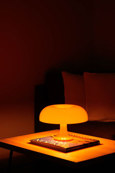 a table with a lamp on it in the dark