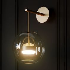 a light that is on the wall next to a door with a round glass ball