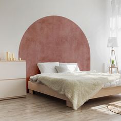 a bedroom with a bed, dresser and window in the corner that has a pink circle on it