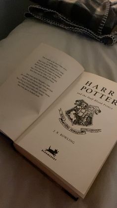 an open harry potter book sitting on top of a bed