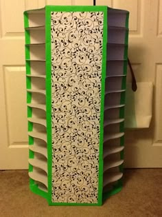 a green and white book case sitting in front of a door with the top open