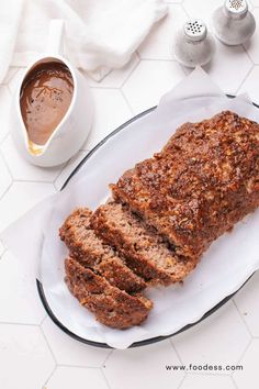 sliced meatloaf on a plate next to a cup of coffee