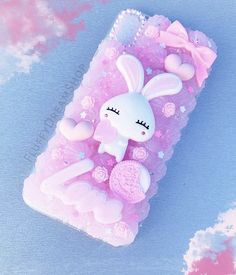 a pink phone case with a white rabbit on it's back and some hearts