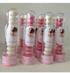 several pink and white candles are in glass tubes with labels on them that say valentine's day