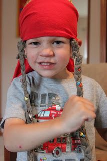 a young boy wearing a red bandana and braids