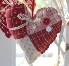 two heart shaped ornaments hanging from a tree