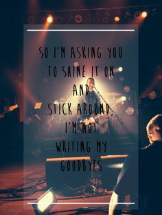 a man sitting in front of a microphone on top of a stage with the words, so i'm asking you to shine it on and stick around i'm not writing my goodbye