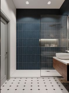 a modern bathroom with blue tile and white fixtures, including a walk - in shower