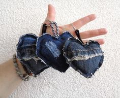 someone is holding their hand out in the air with two pieces of torn up denim