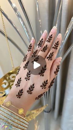 a woman's hand with henna on it and bracelets around her wrist