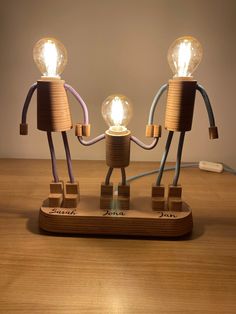 two lightbulbs are connected to each other on a wooden base