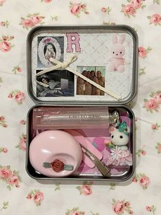 two tins filled with pink items sitting on top of a floral tablecloth covered floor