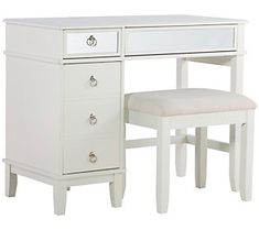 a white dressing table with a stool and mirror