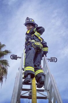 a firefighter sitting on top of a ladder