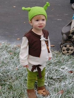 a little boy wearing a costume standing in the grass