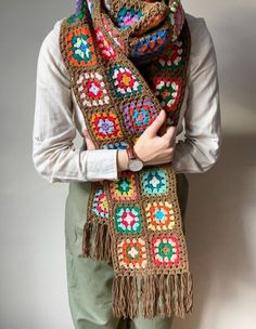 a woman is wearing a crocheted scarf