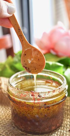 a spoon full of sunflower seed dressing being drizzled over the jar