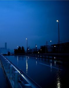 a city street at night with lights reflecting in the water