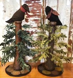 two birds are sitting on top of some trees in the middle of a wooden table