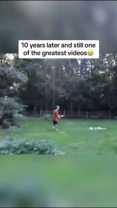 a man is throwing a frisbee on the grass with trees in the background