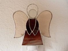 a stained glass angel is hanging on the wall next to a light switch and paper towel dispenser