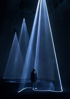 a person standing in front of three white lights