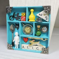 a miniature blue shelf with various items on it, including a clock and other things