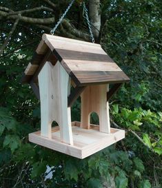 a wooden bird house hanging from a tree