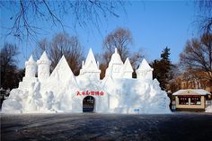 an ice castle with snow on the ground and trees in the backgrouds