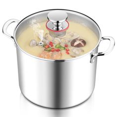 a pot filled with soup on top of a white table next to a silver lid