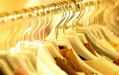 there are many different types of clothes hanging on the rack in the store or closet