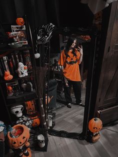 a woman taking a selfie in front of a mirror with halloween decorations on it