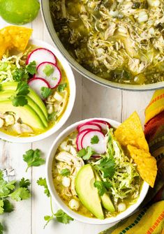 two bowls of chicken tortilla soup with avocado, radishes and cilantro