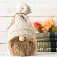 a stuffed animal wearing a knitted hat on top of two books next to flowers