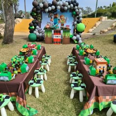 a table set up for a minecraft themed birthday party with balloons and streamers